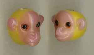 Glazen figuurkraal, roze/geel aapje, ca. 25x20mm, rijggat ca. 30mm. Per stuk